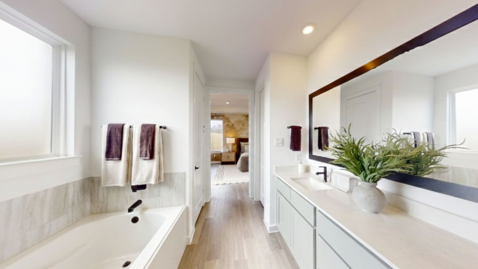 primary bathroom with two sinks tub and shower