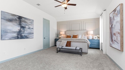 Primary bedroom with carpeted floors, two large windows, and trey ceilings.