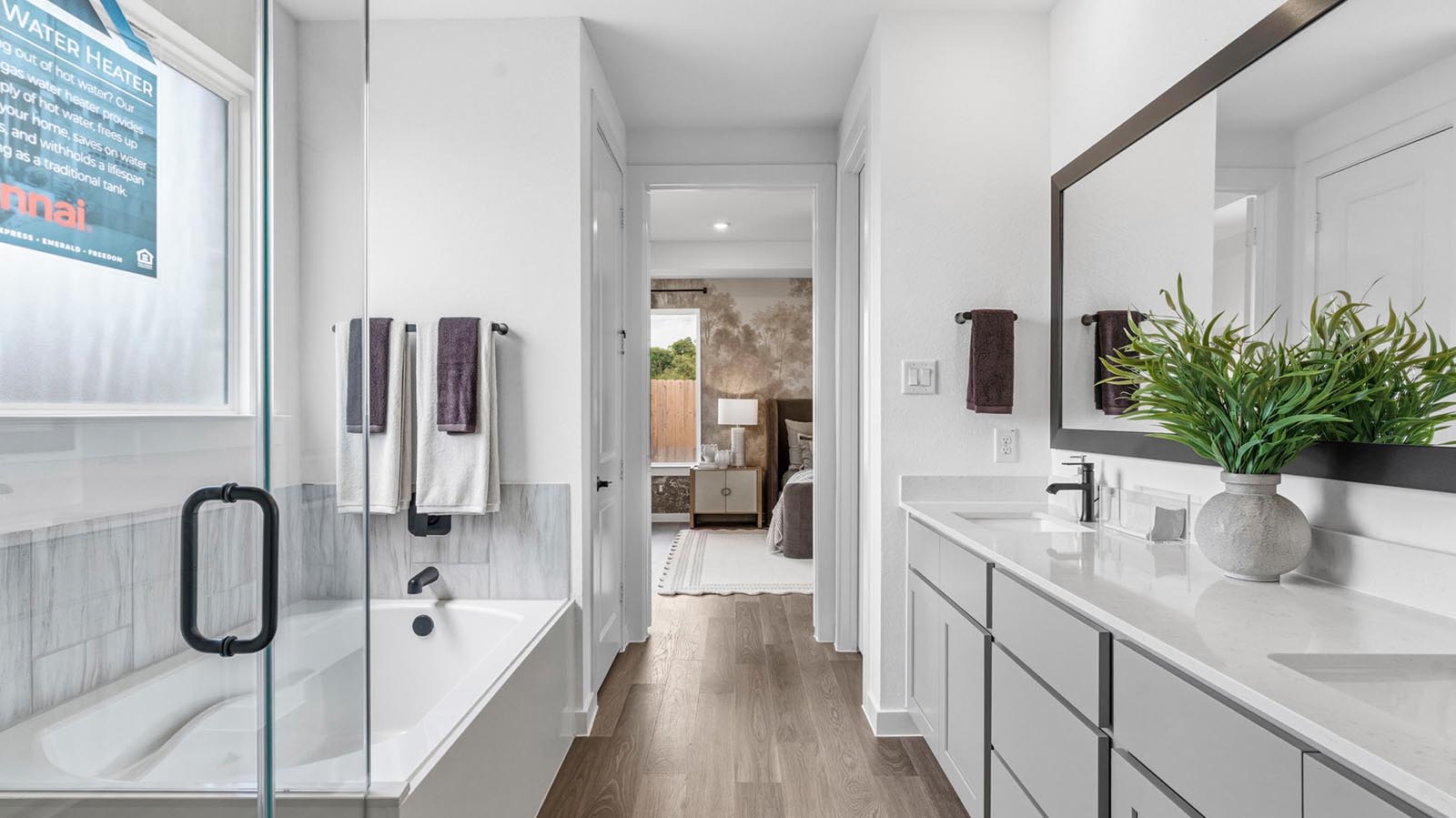 Modern primary bathroom with double vanities, granite countertops, and a glass-enclosed shower with a walk-in closet.