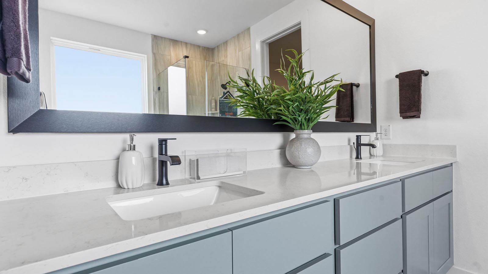 Luxurious primary bathroom with dual vanities, a soaking tub, glass-enclosed shower and walk-in closet.