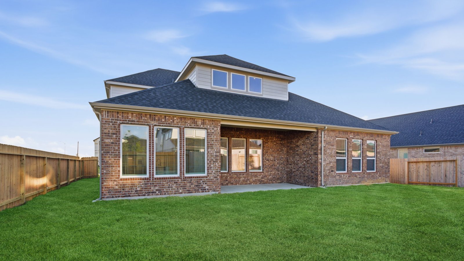 Outdoor covered patio with seating area overlooking a well-maintained lawn, perfect for relaxation.