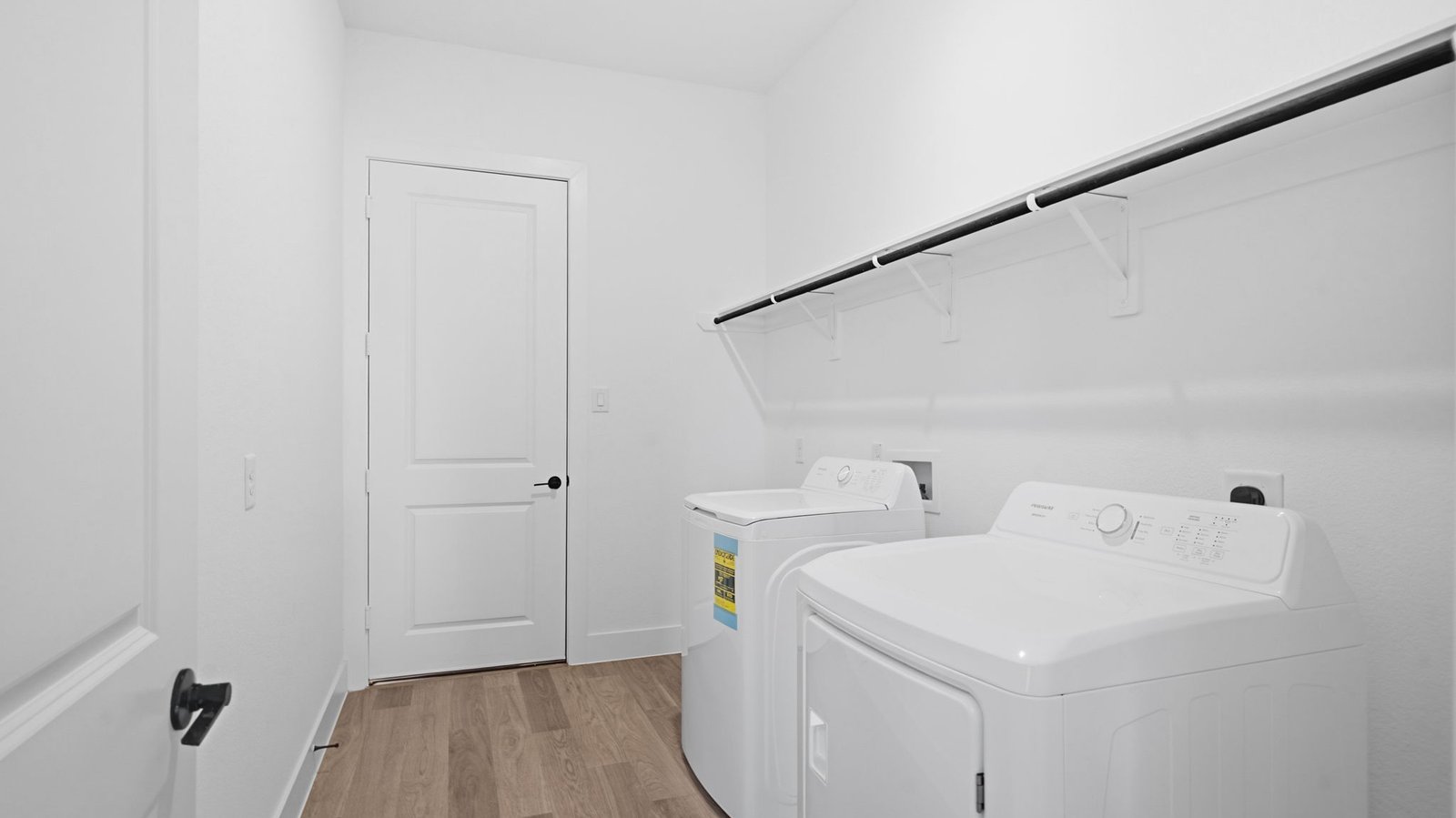 A laundry room featuring a washer and dryer, neatly arranged with ample space for laundry tasks and storage.