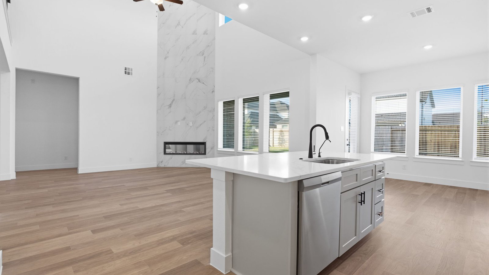 An open concept kitchen with an island with bar seating and access to the living and dining areas.