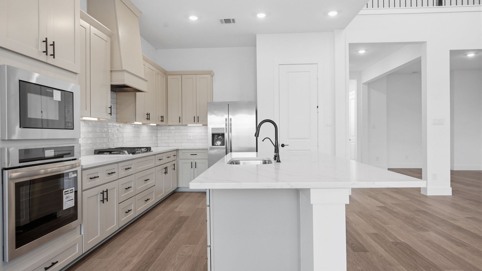 Bright and spacious kitchen with granite countertops, stainless steel appliances, and an island with bar seating.