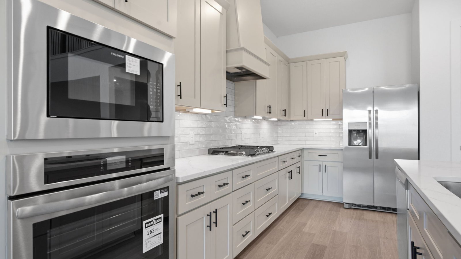 Bright and spacious kitchen with granite countertops, stainless steel appliances, and an island with bar seating.