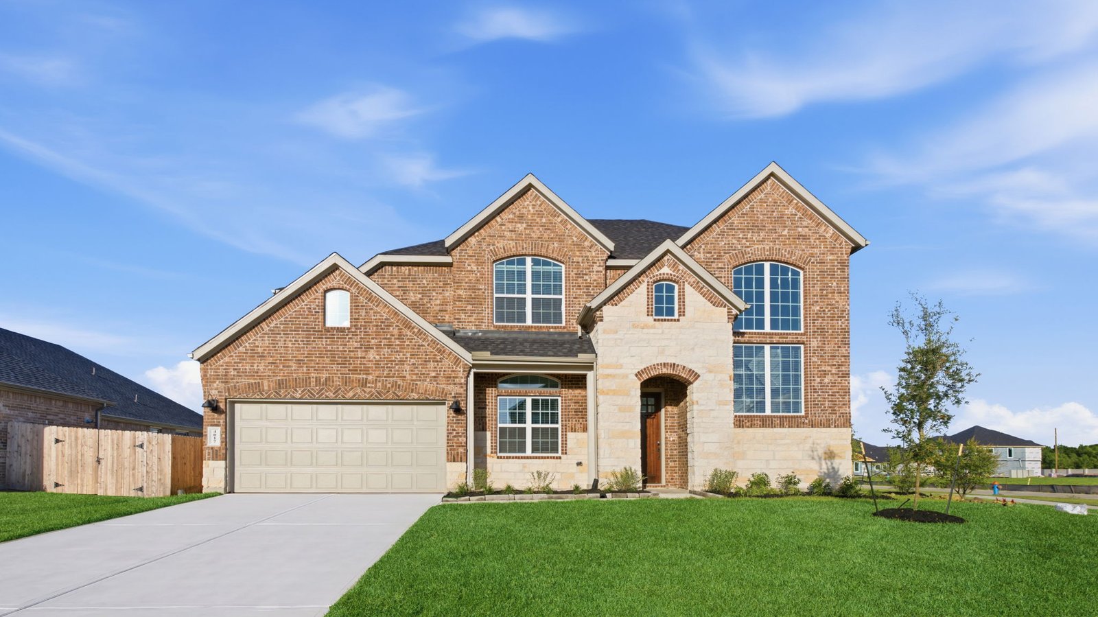 Newly built two story home with modern architecture, a double garage, and landscaped front yard.
