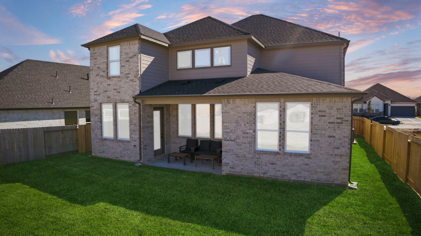 avery two story brick model home in pearland texas back elevation at sunset
