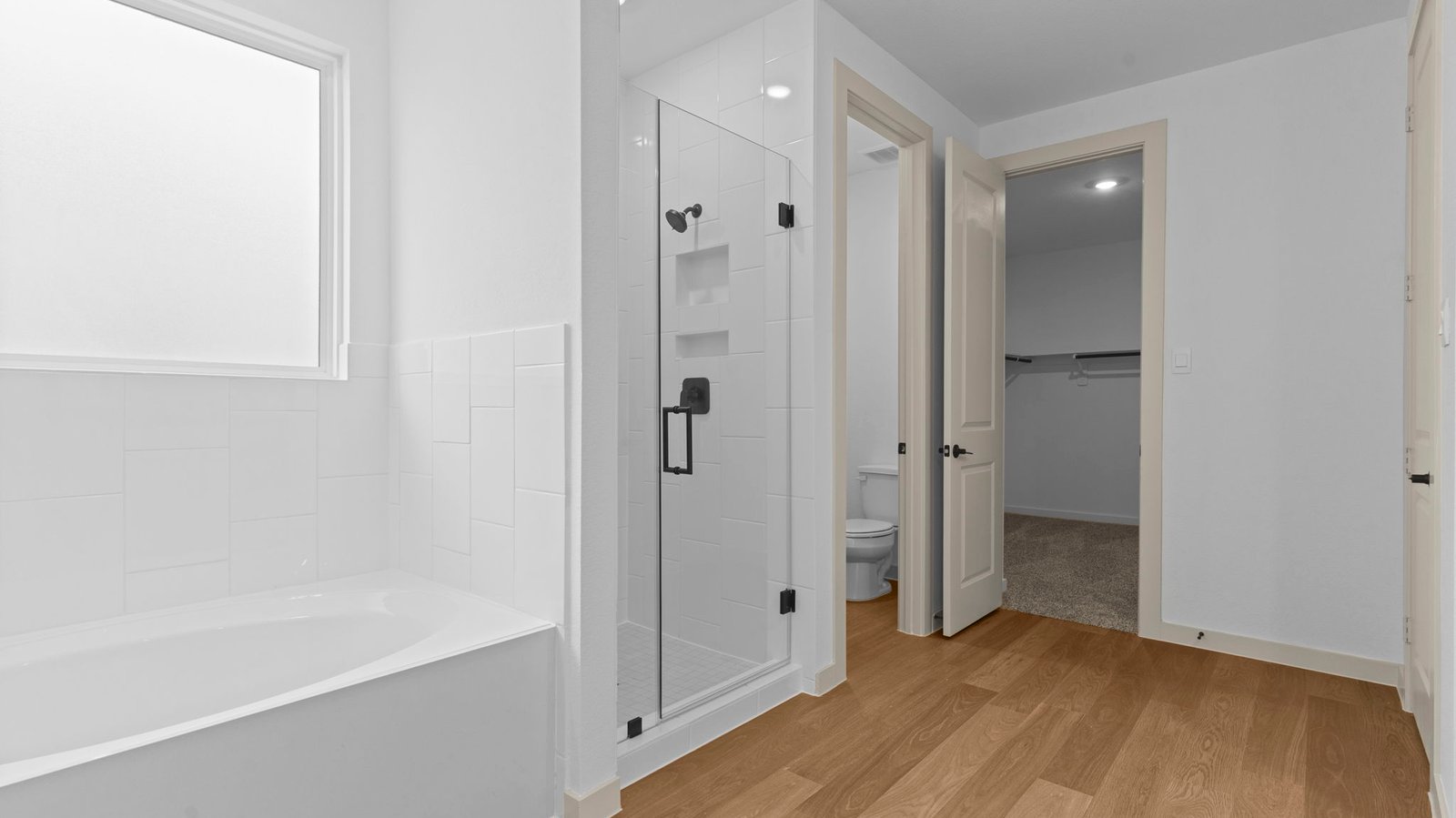 Primary bathroom with a glass-enclosed standing shower and separate soaking tub.