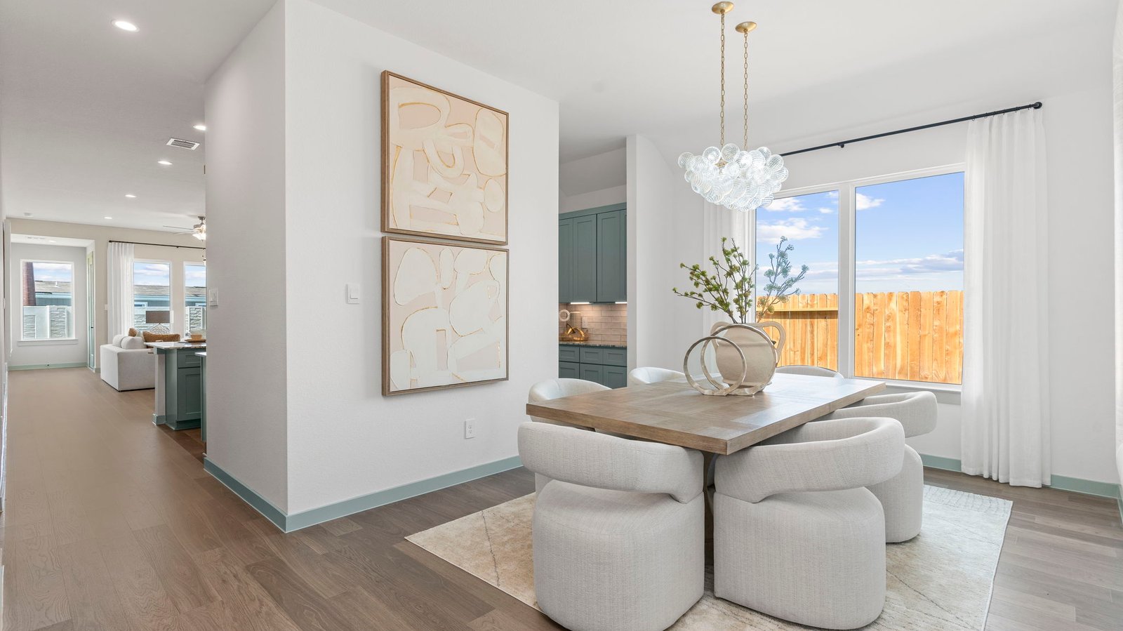 Formal dining area with large windows, vinyl wood floors, and view of the backyard.