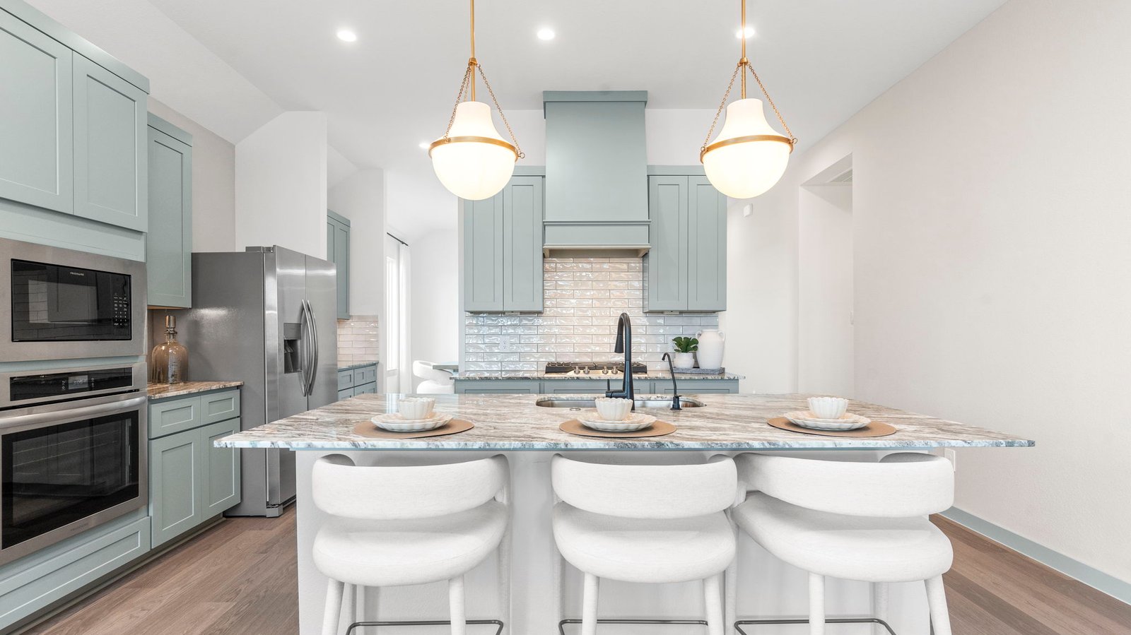 An open concept kitchen with an island with bar seating and access to the living and dining areas.