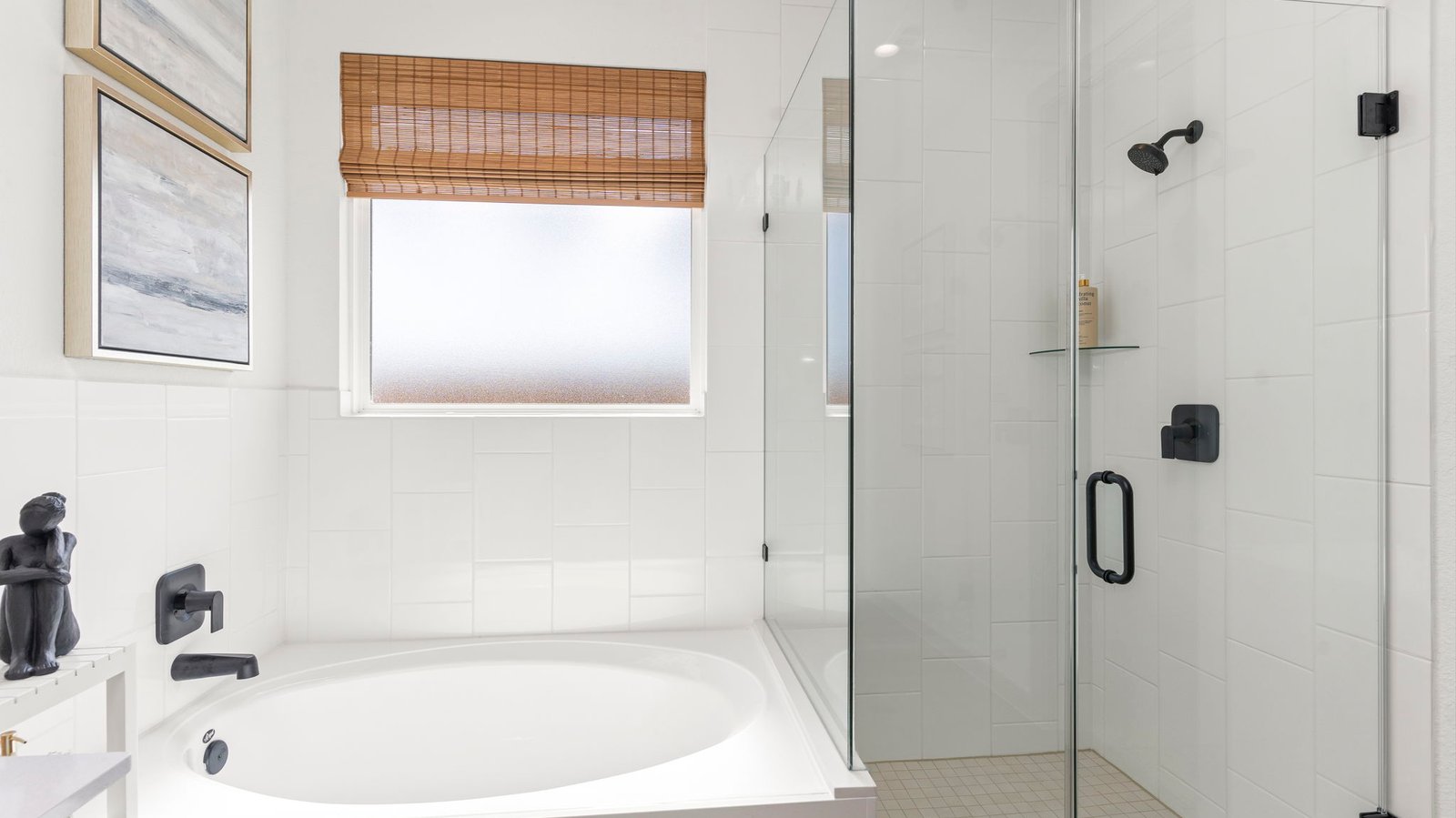 Modern primary bathroom with double vanities, quartz countertops, and a glass-enclosed shower with a walk-in closet.