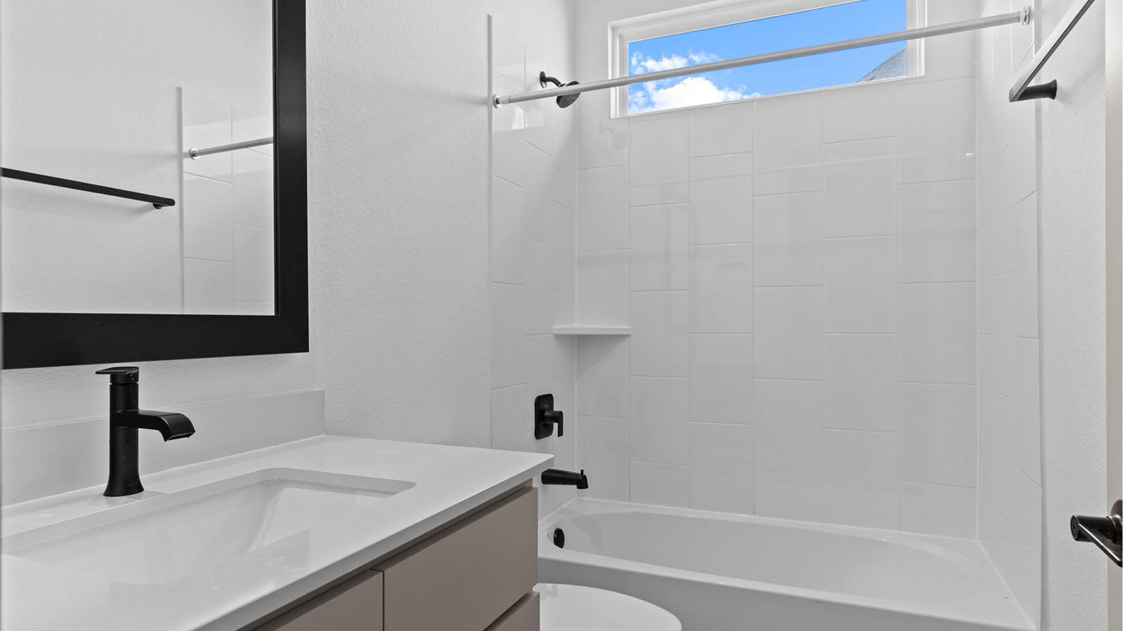 A well-designed bathroom equipped with quartz countertops, a standing tub, and a single vanity.