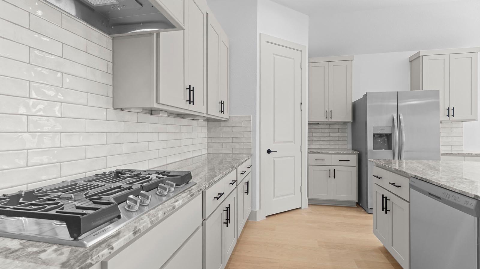 Bright and spacious kitchen with granite countertops, stainless steel appliances, and an island with bar seating.