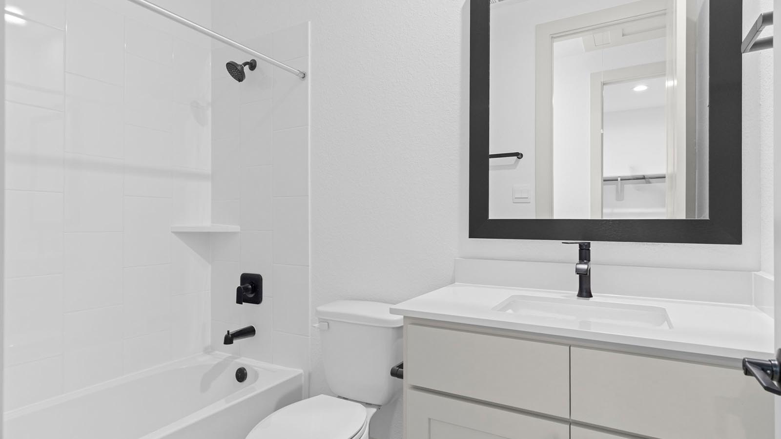 A well-designed bathroom equipped with quartz countertops, a standing tub, and a single vanity.