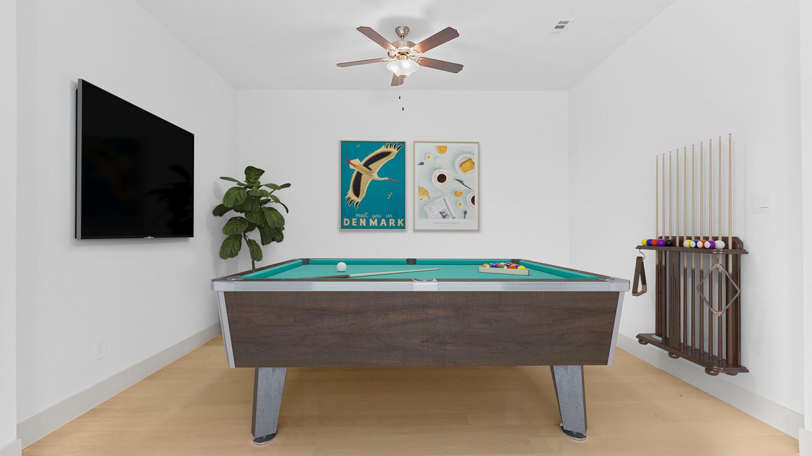 A spacious game room with plenty of natural light from windows overlooking side of the home