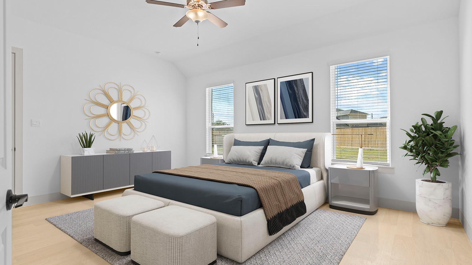 A cozy living room featuring large windows for natural lighting, vinyl wood flooring and a view to the kitchen and dining area.