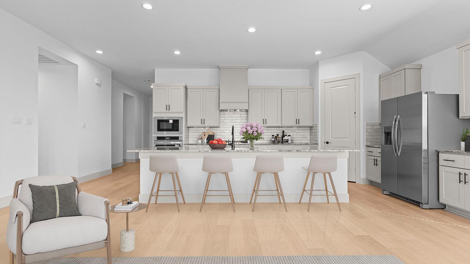 An open concept kitchen with an island with bar seating and access to the living and dining areas.