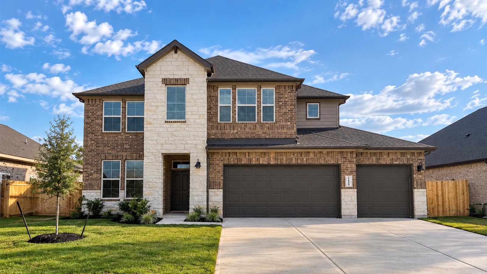 chloe two story brick exterior with a three car garage