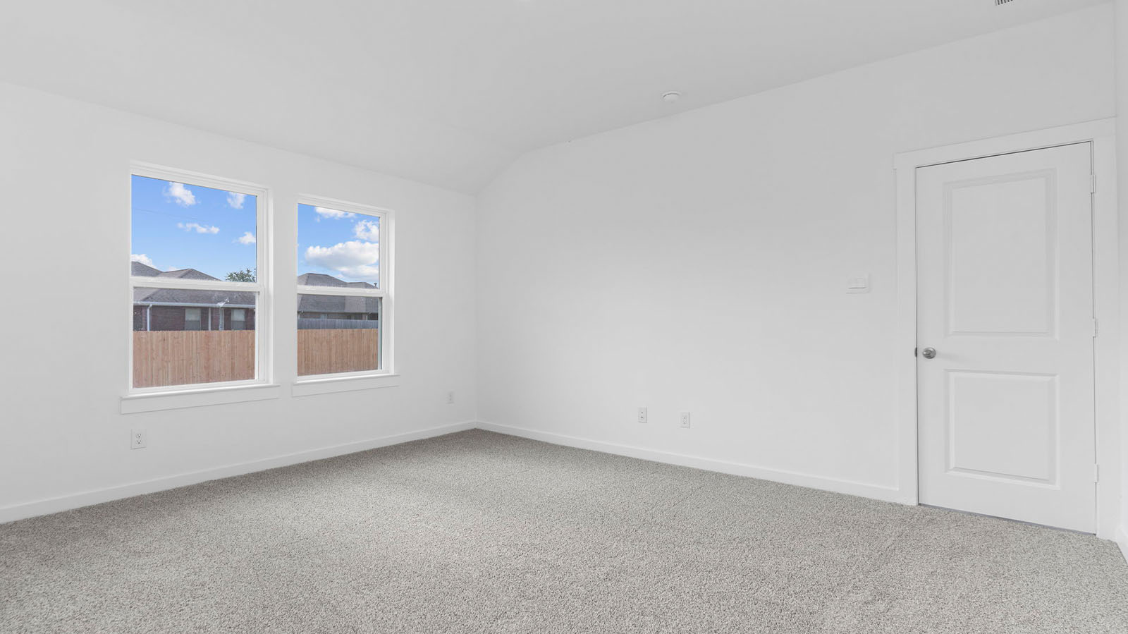 Spacious primary bedroom with two large windows