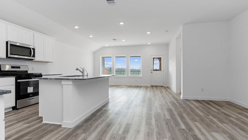 Open concept kitchen, dining, and living room with three large windows and a back patio door