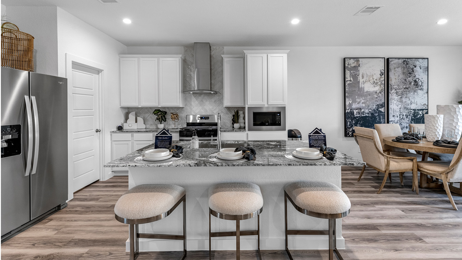 Bright and spacious kitchen with quartz countertops, stainless steel appliances, and an island with bar seating.