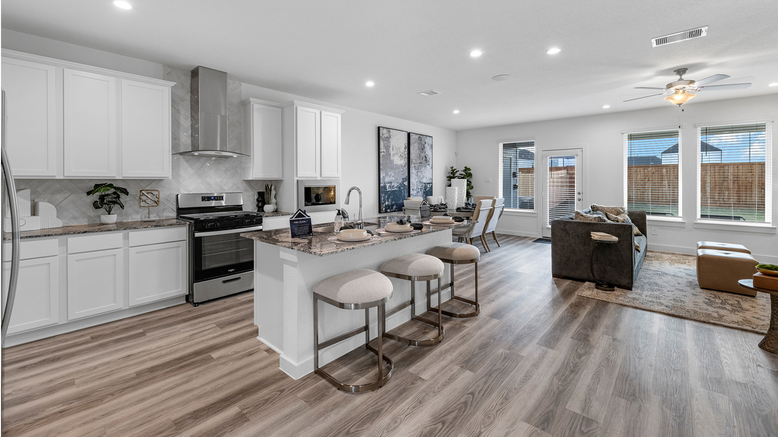 Bright and spacious kitchen with quartz countertops, stainless steel appliances, and an island with bar seating.