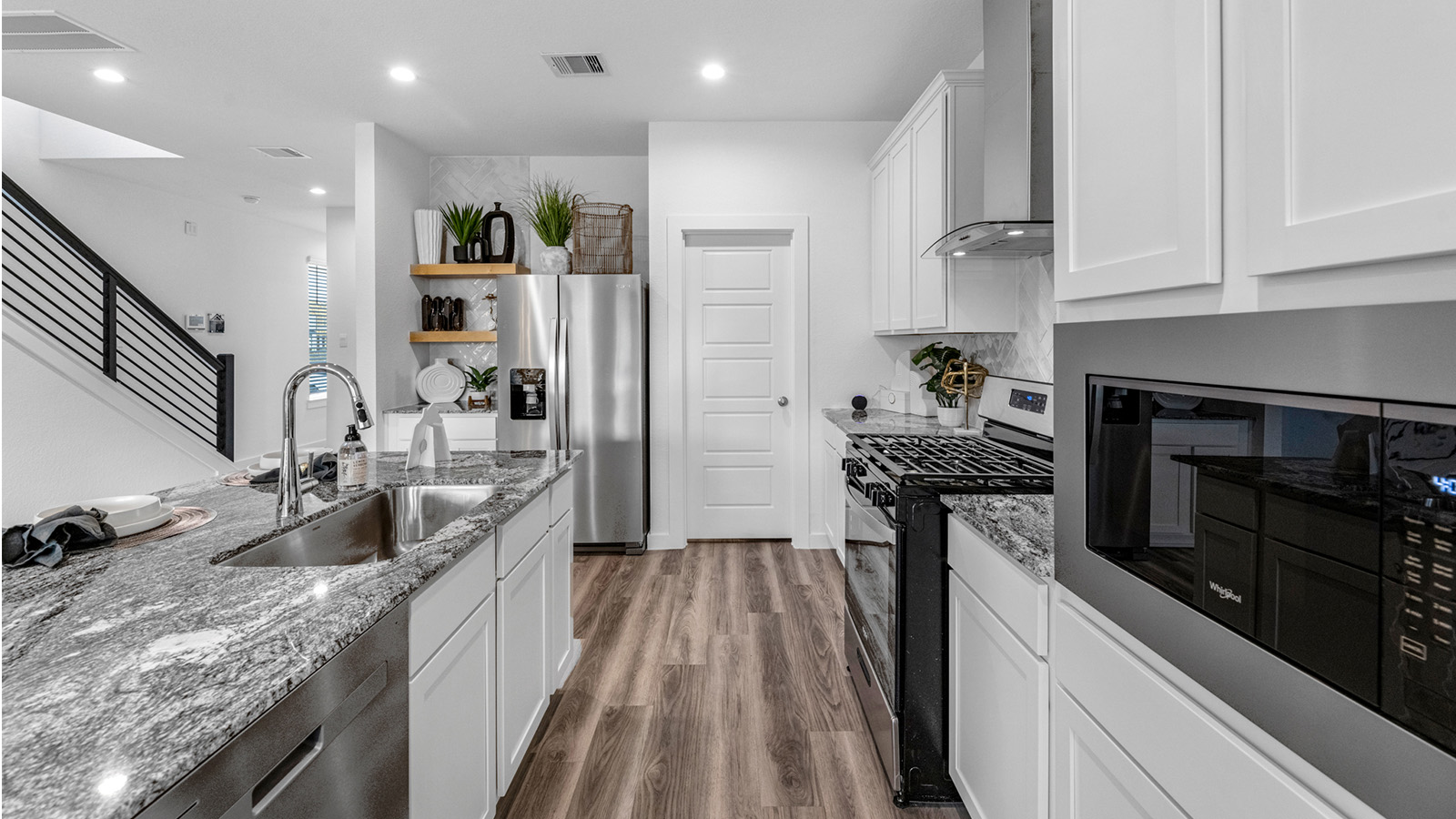 An open concept kitchen with an island with bar seating and access to the living and dining areas.