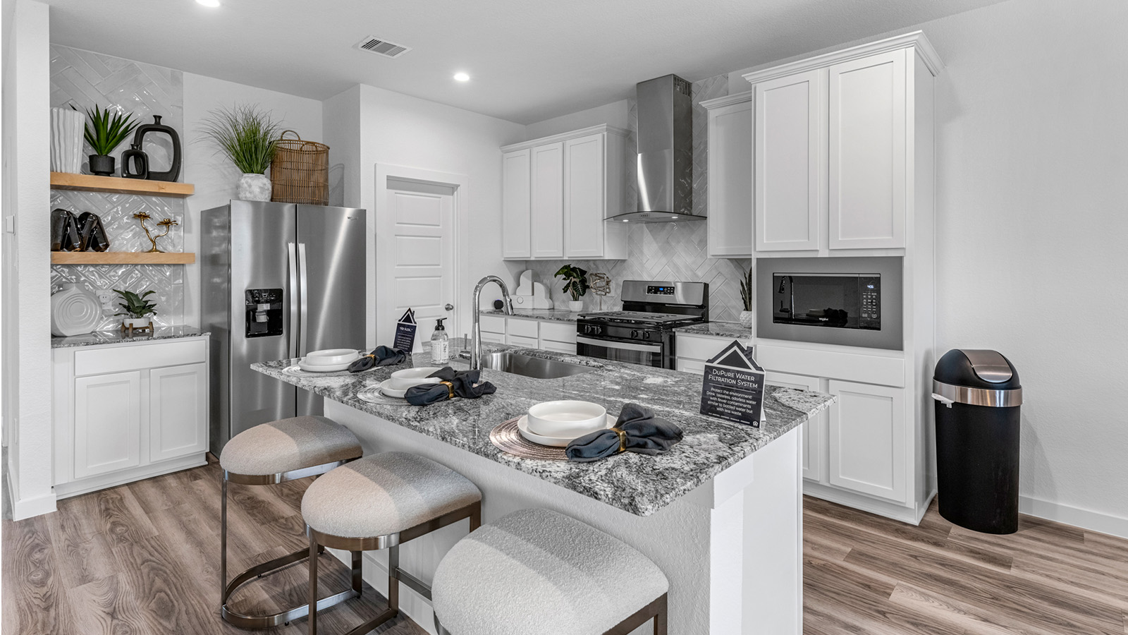 An open concept kitchen with an island with bar seating and access to the living and dining areas.