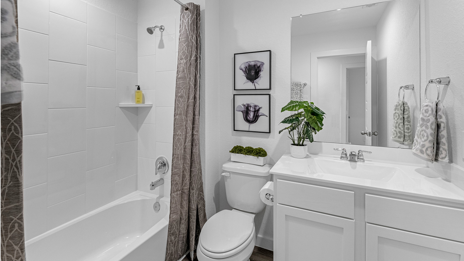 A well-designed bathroom equipped with quartz countertops, a standing tub, and a single vanity.