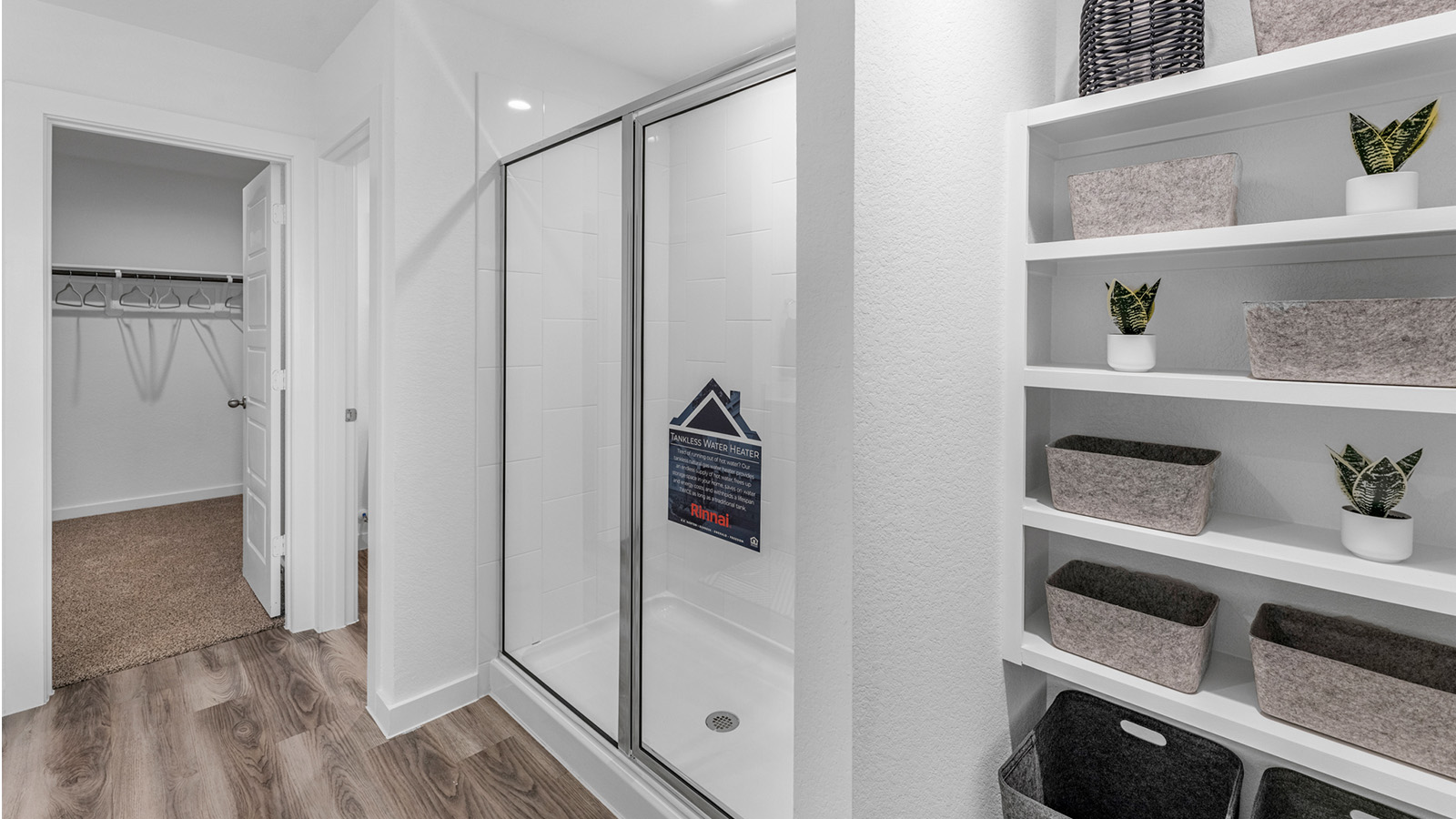 Modern primary bathroom with double vanities, quartz countertops, and a glass-enclosed shower with a walk-in closet.