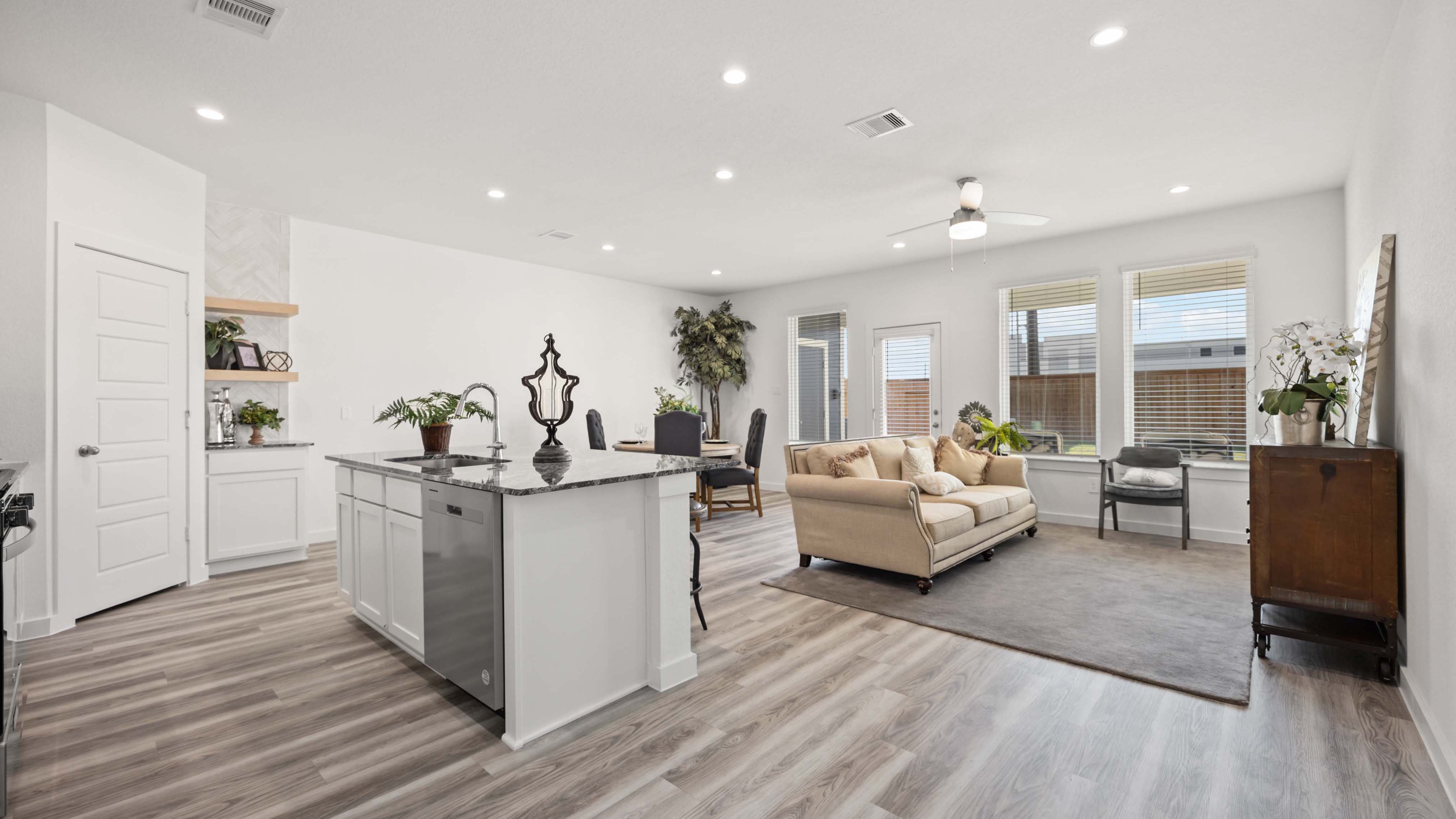 An open concept kitchen with an island with bar seating and access to the living and dining areas.