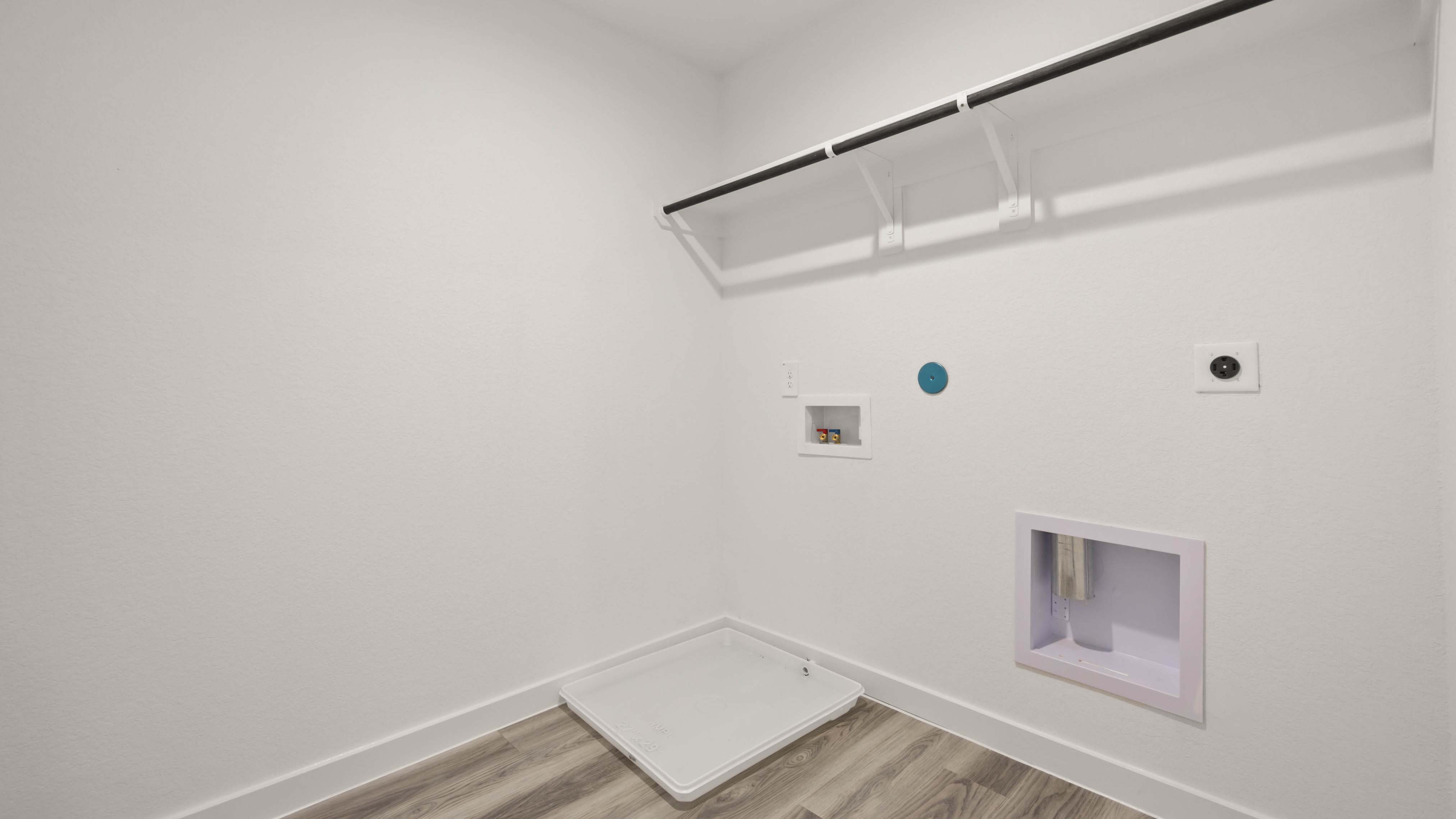 A laundry room featuring a washer and dryer, neatly arranged with ample space for laundry tasks and storage.