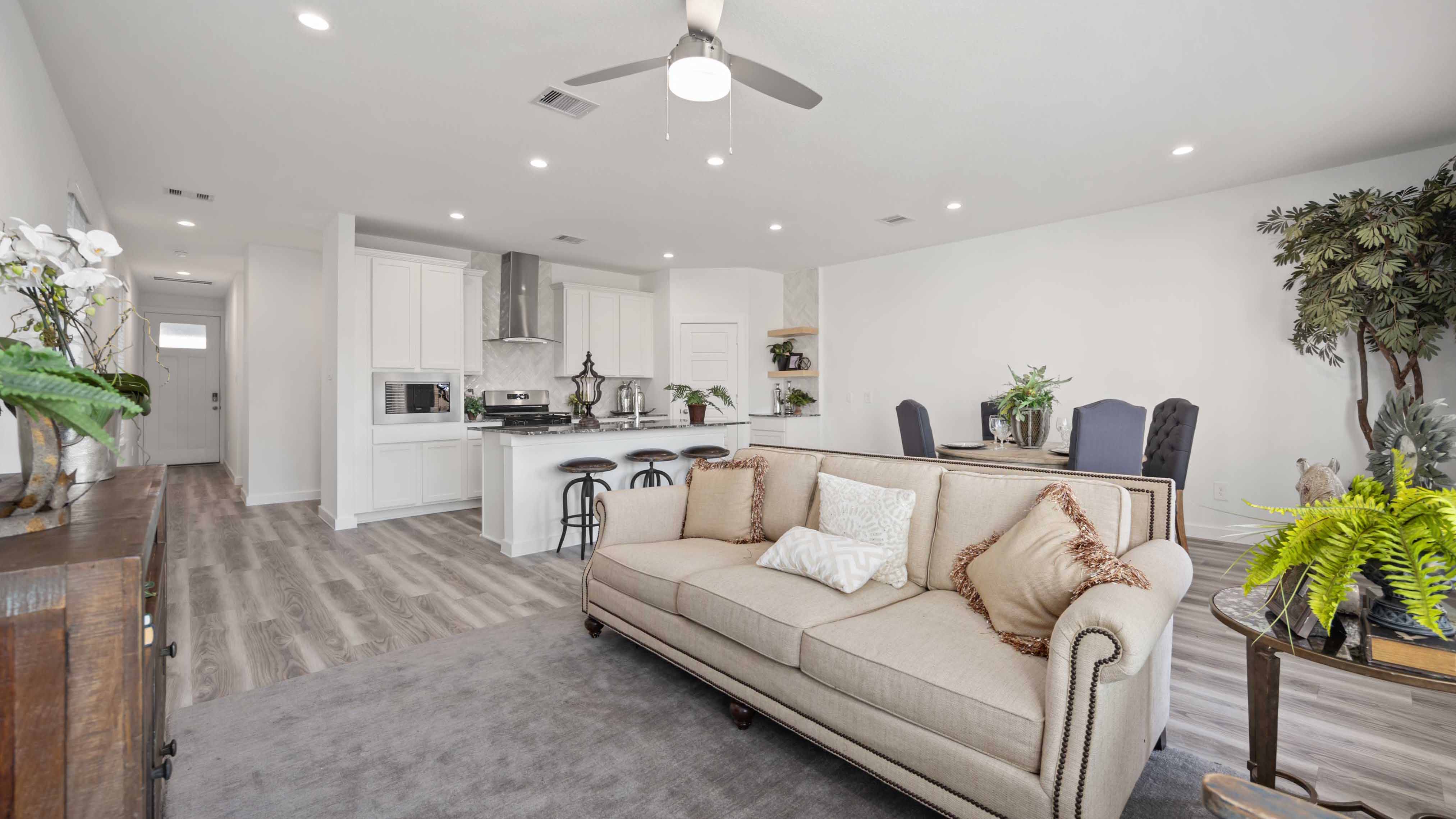 A well-organized living room that includes a kitchen and dining area, creating a warm and welcoming environment for gatherings.