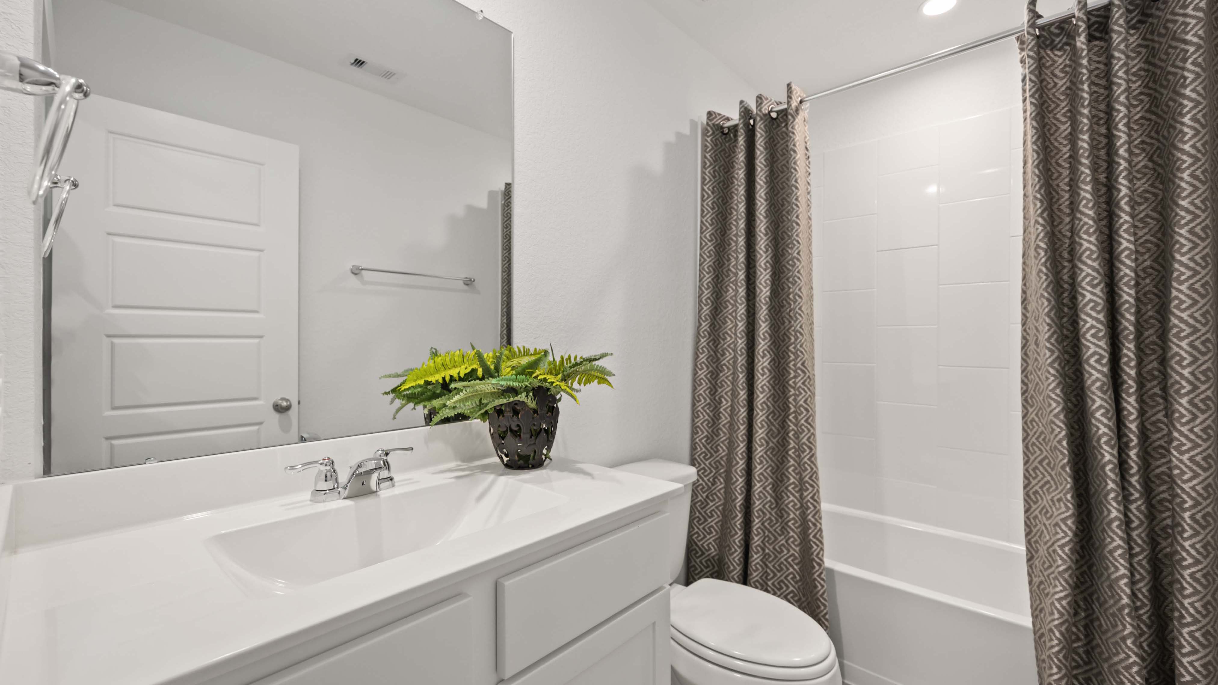 A well-designed bathroom equipped with quartz countertops, a standing tub, and a single vanity.