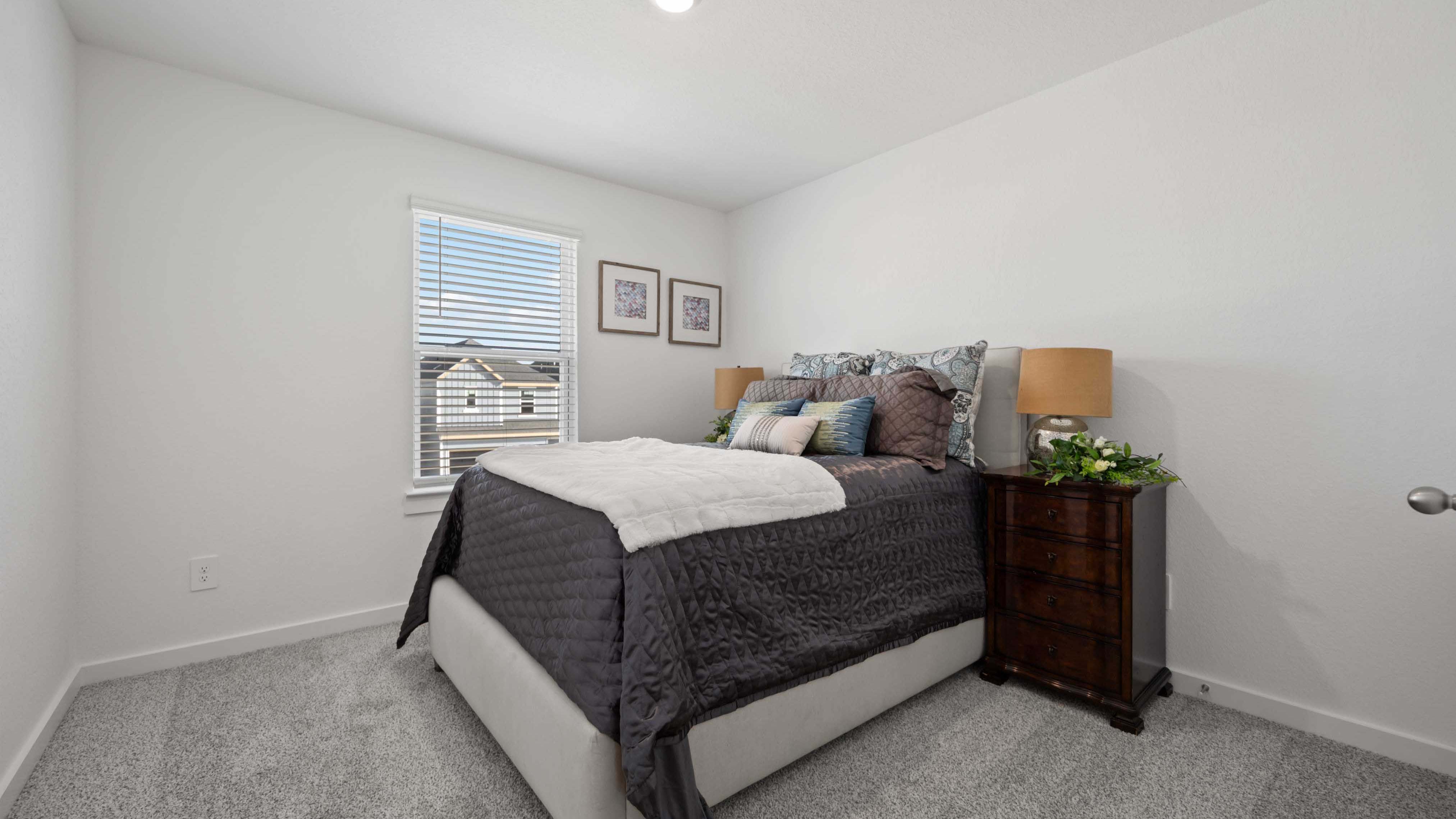 Comfortable guest bedroom featuring neutral-toned walls, carpeted flooring, and a separate closet.