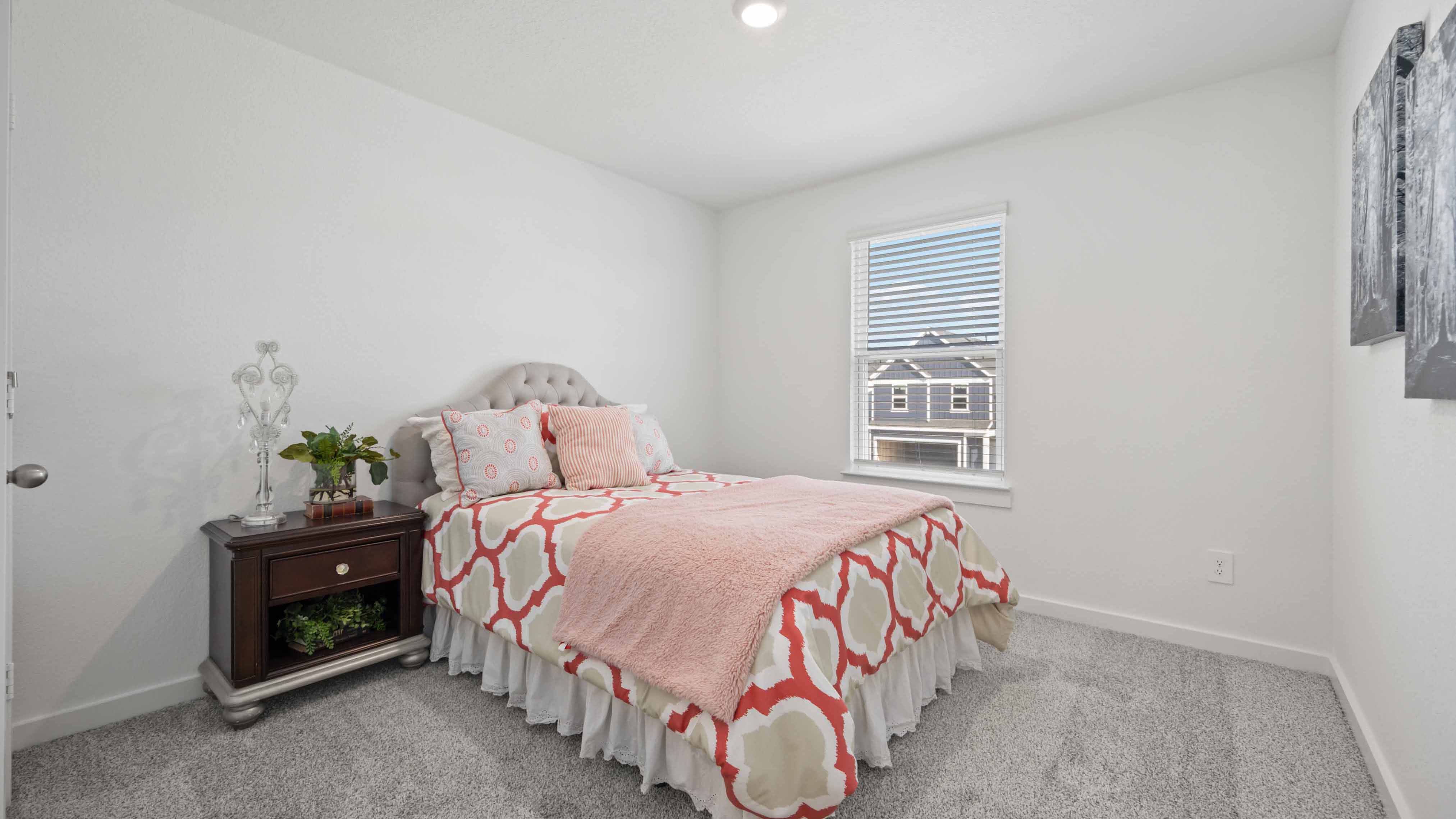 Comfortable guest bedroom featuring neutral-toned walls, carpeted flooring, and a separate closet.