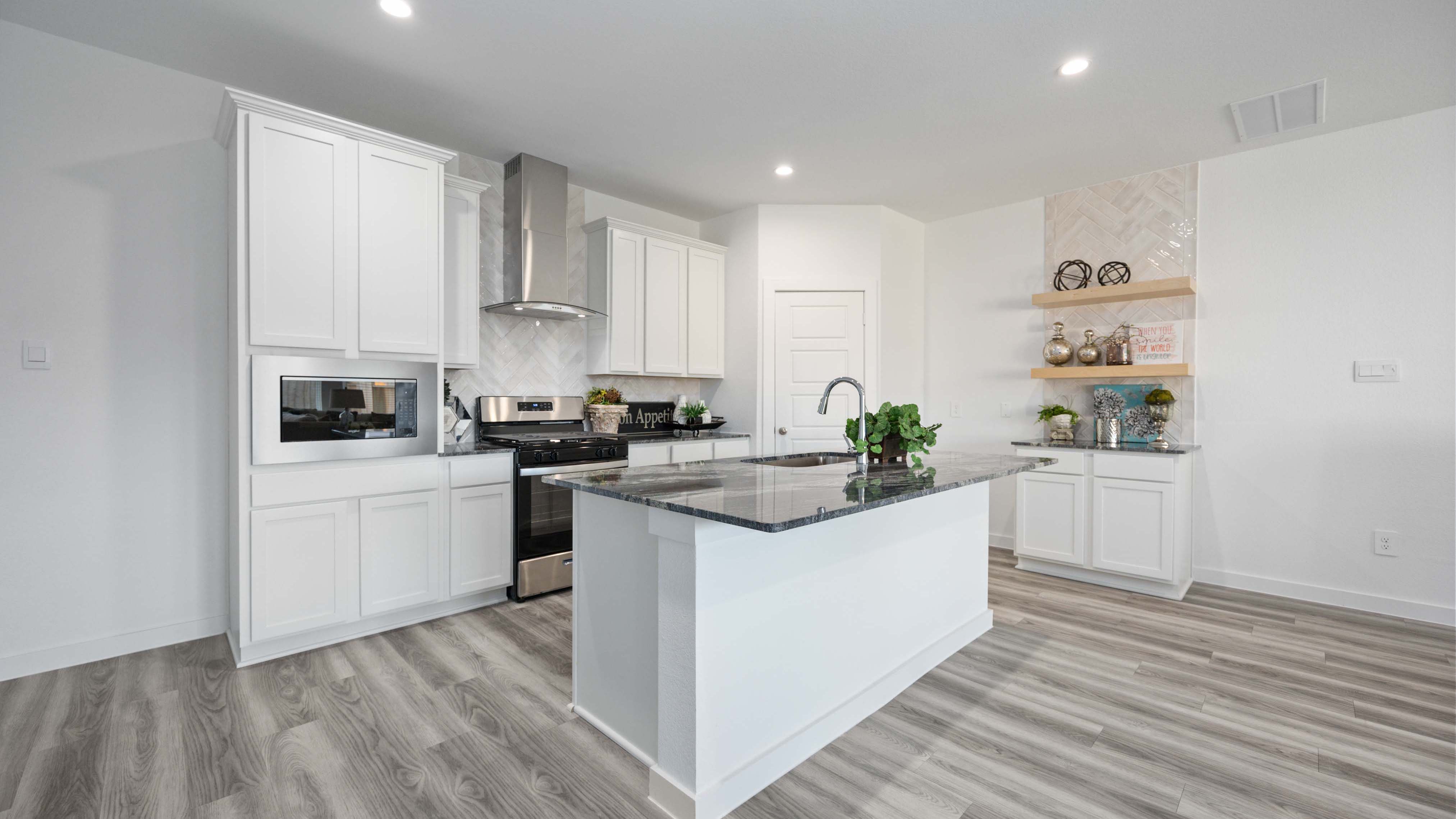 Bright and spacious kitchen with granite countertops, stainless steel appliances, and an island with bar seating.