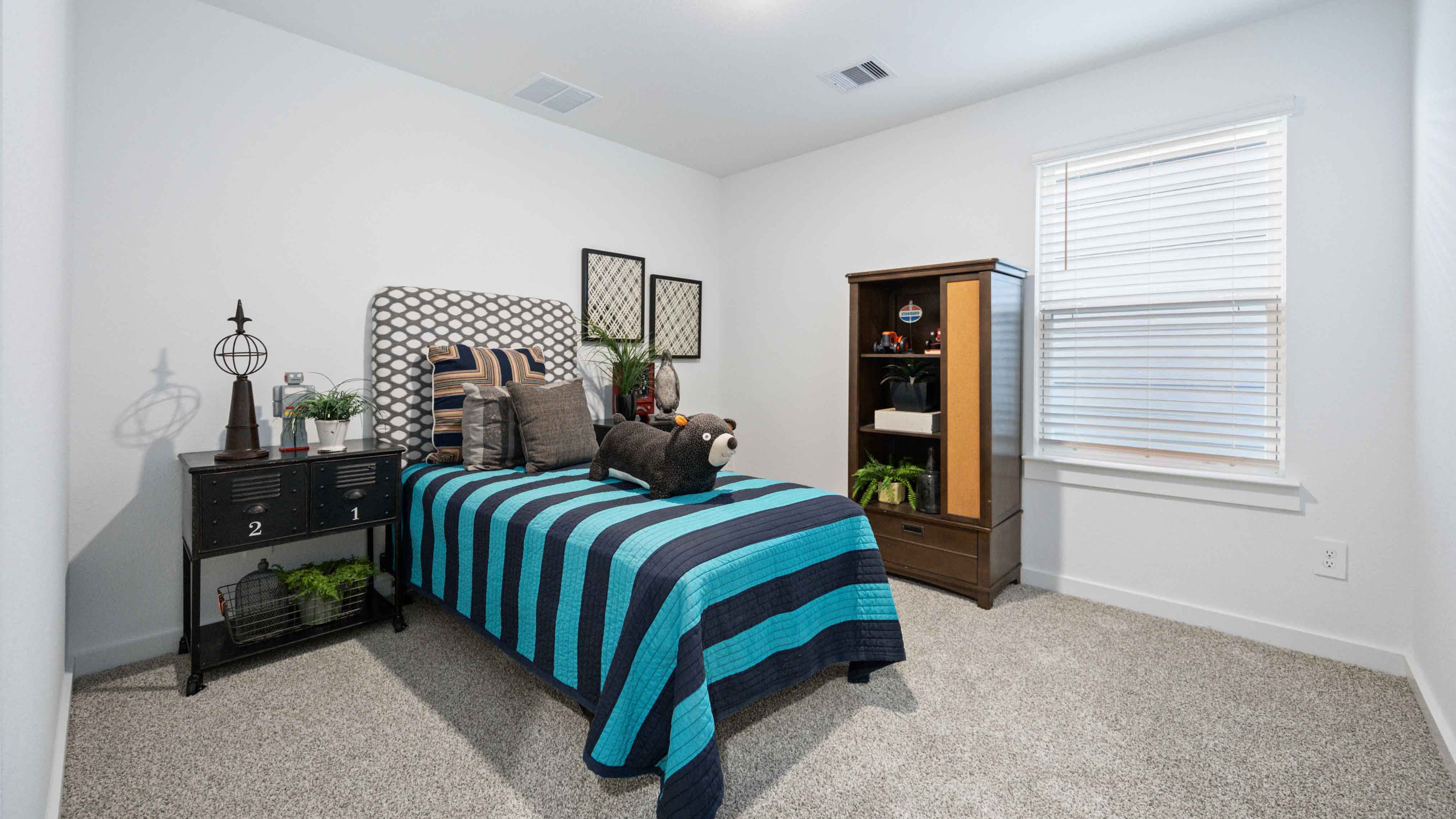 Comfortable guest bedroom featuring neutral-toned walls, carpeted flooring, and a separate closet.
