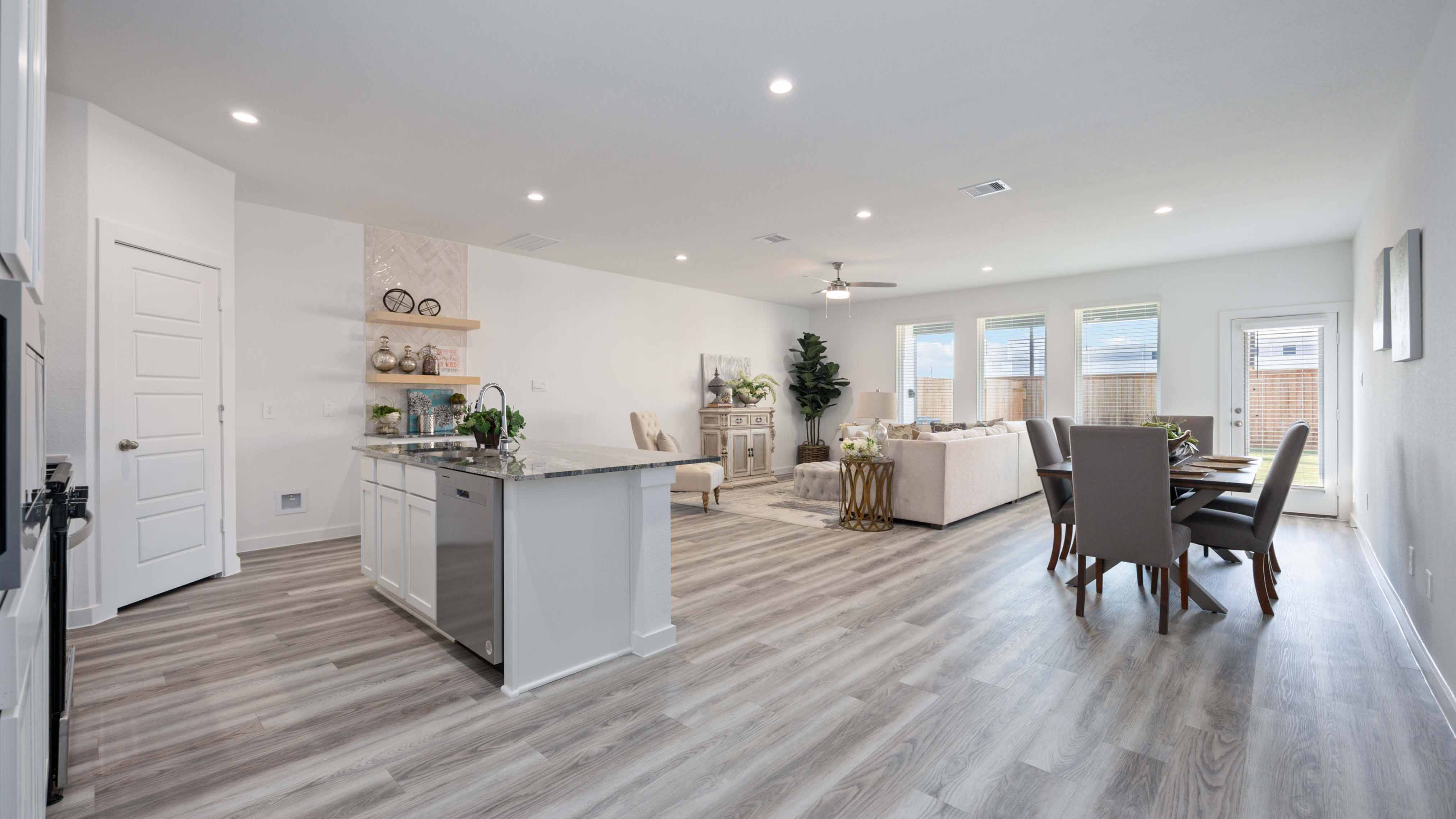 An open concept kitchen with an island with bar seating and access to the living and dining areas.