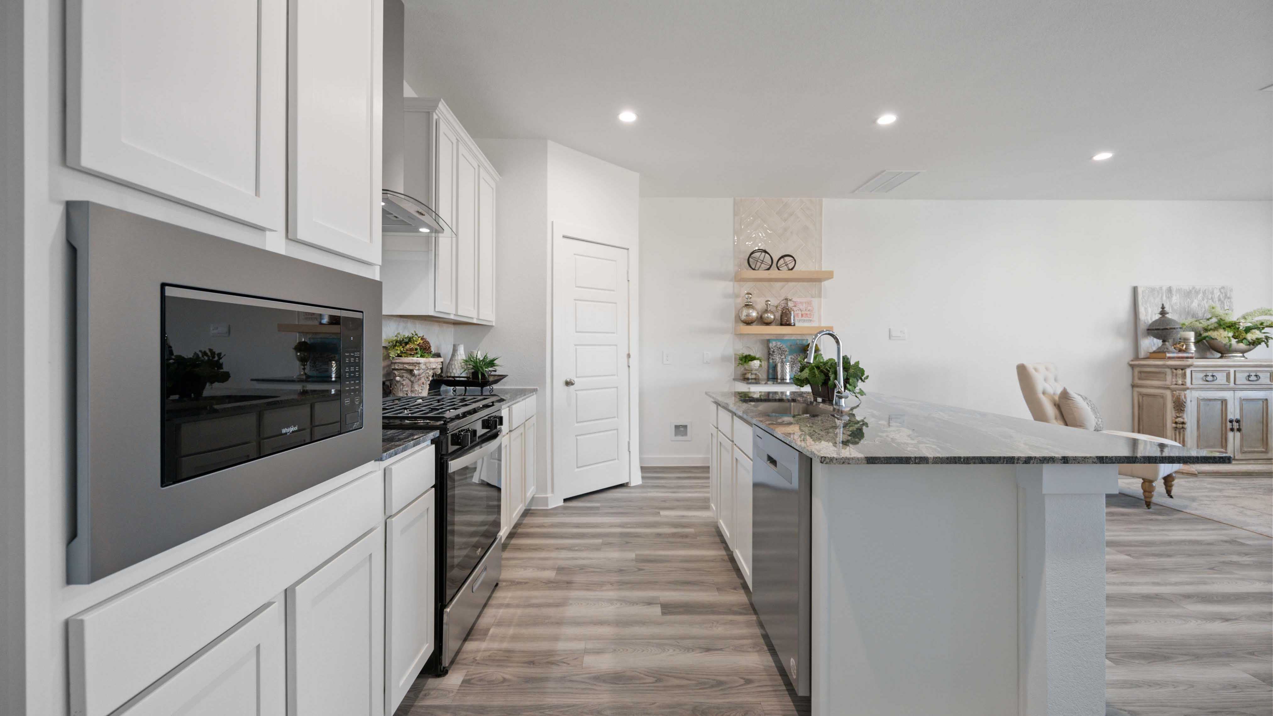 Bright and spacious kitchen with quartz countertops, stainless steel appliances, and an island with bar seating.