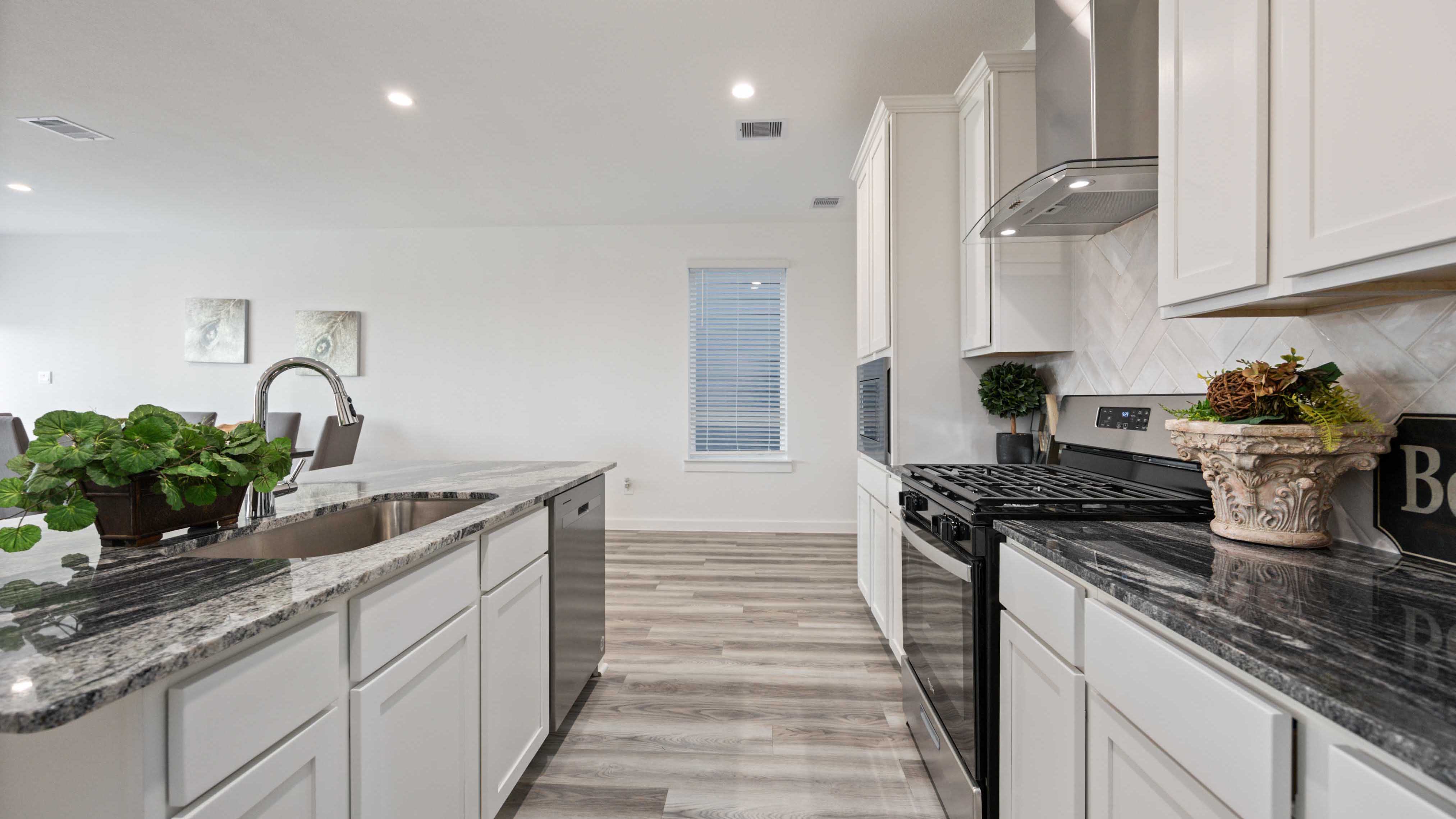 Bright and spacious kitchen with quartz countertops, stainless steel appliances, and an island with bar seating.