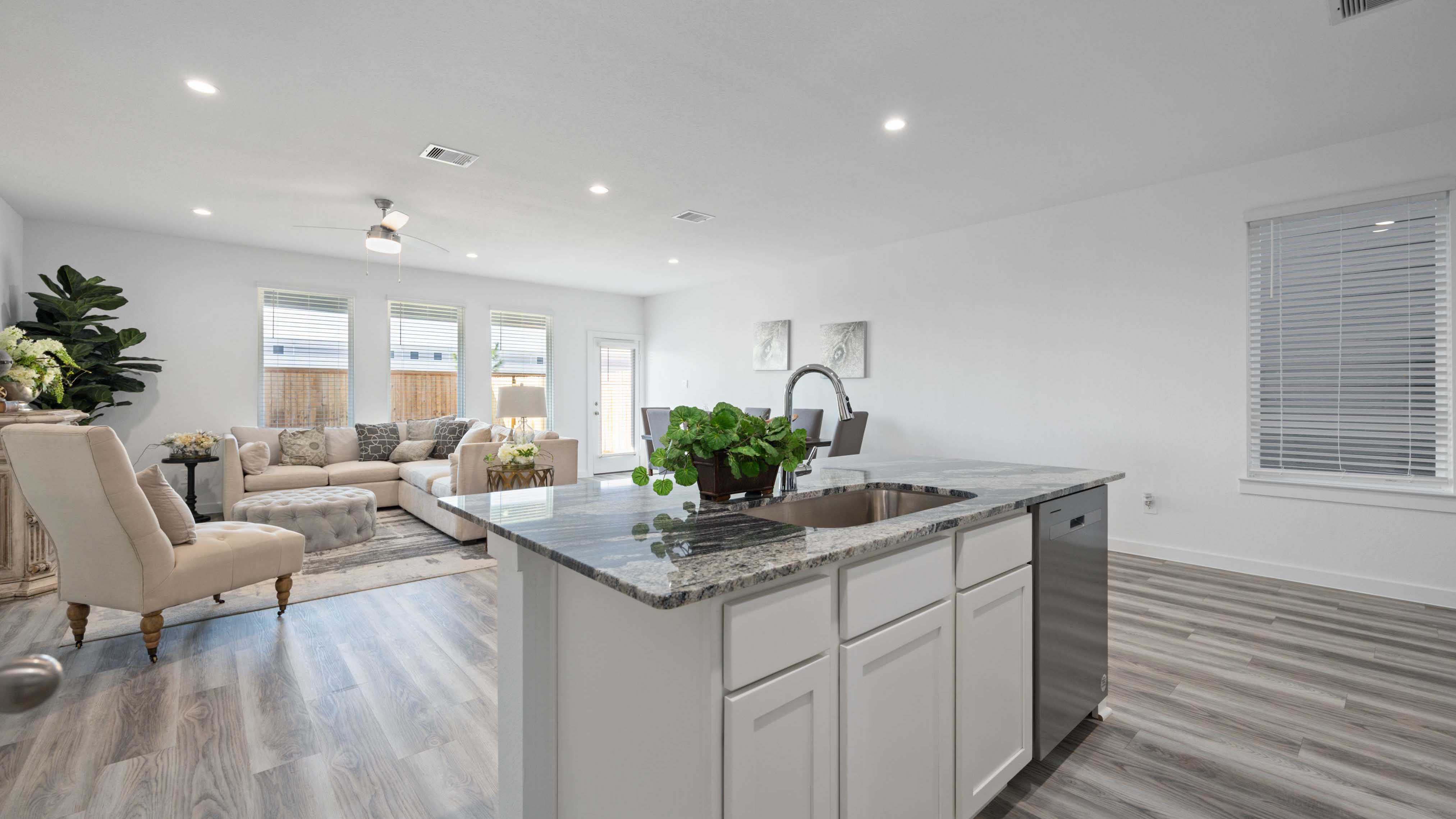 An open concept kitchen with an island with bar seating and access to the living and dining areas.