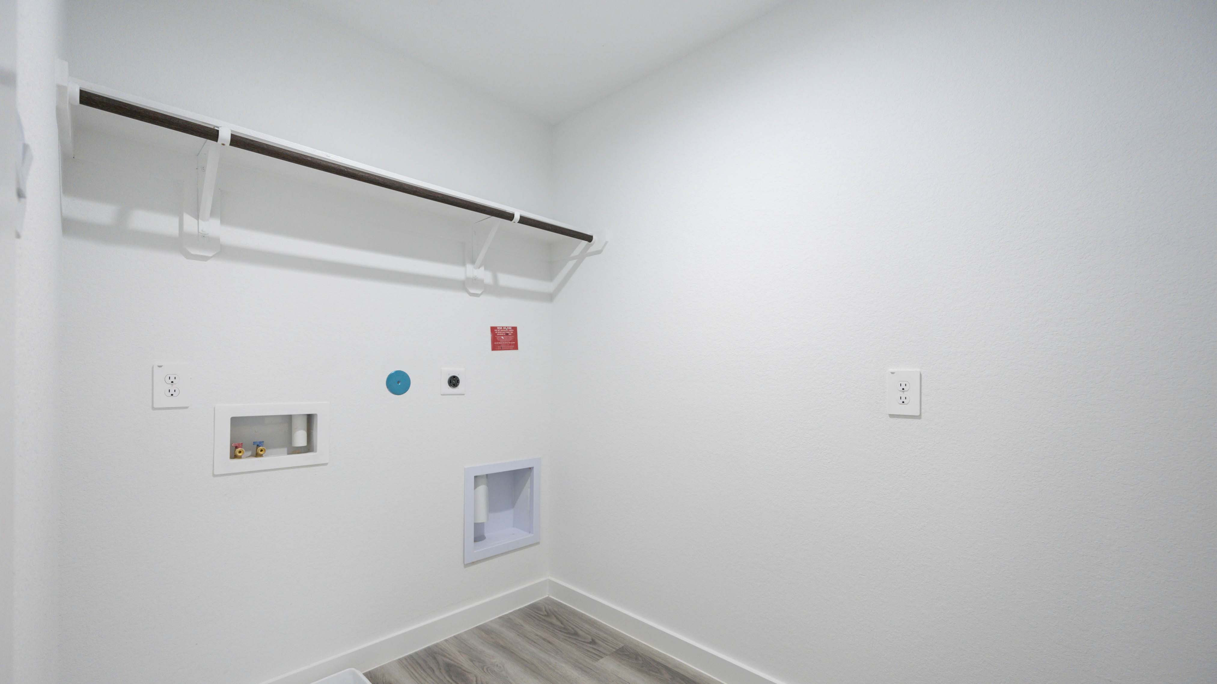 Spacious laundry room with washer and dryer connections, hanging rod, and vinyl wood flooring