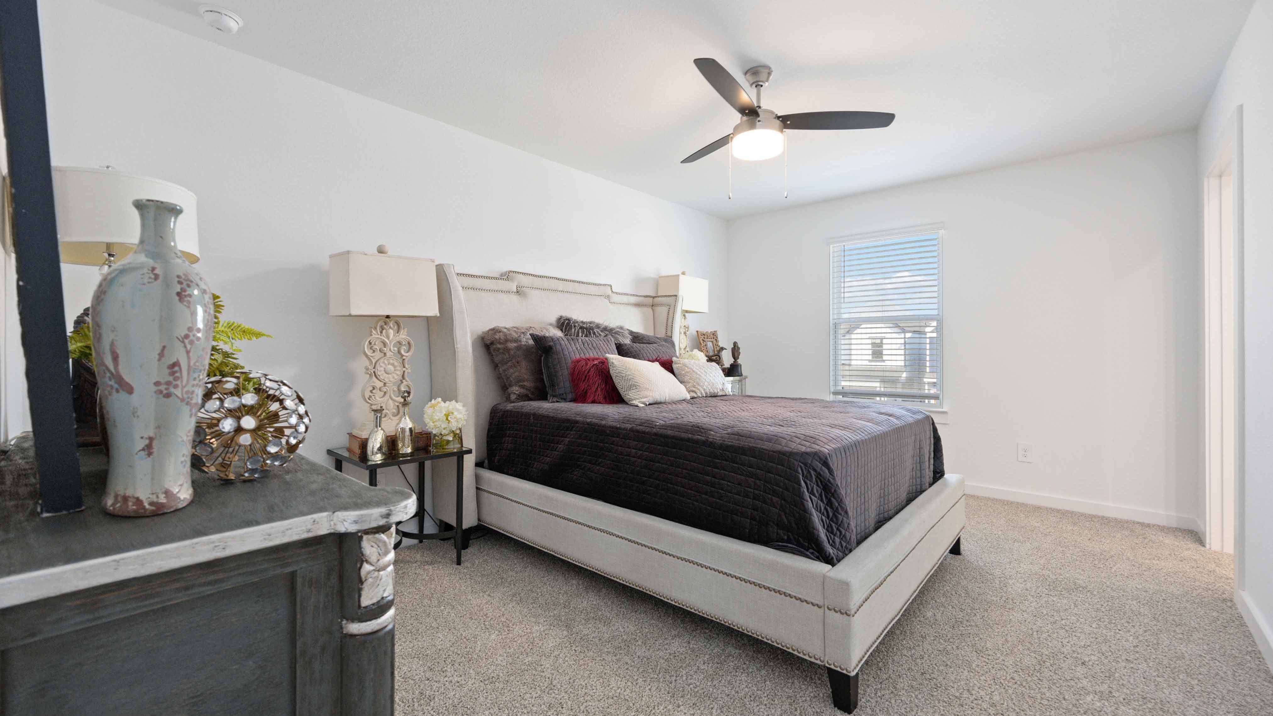 A spacious primary bedroom emphasizing open space and natural lighting with large windows.