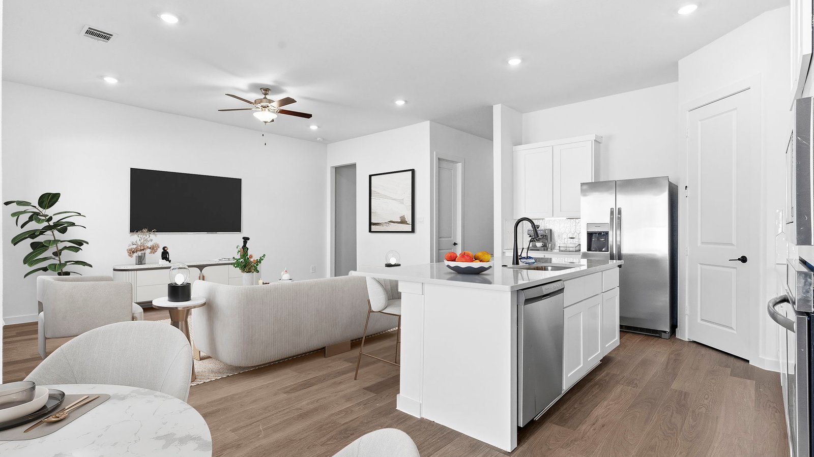 A well-organized living room that includes a kitchen and dining area, creating a warm and welcoming environment for gatherings.
