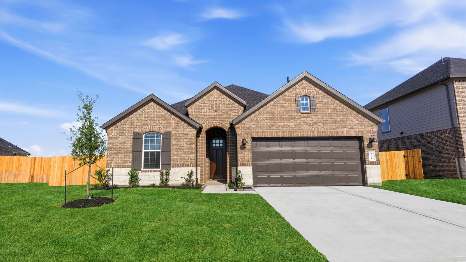 Newly built single story home with traditional architecture, a double garage, and landscaped front yard.