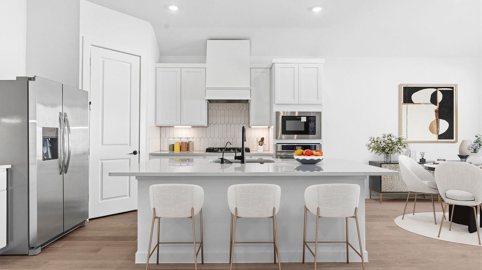 An open concept kitchen with an island with bar seating and access to the living and dining areas.