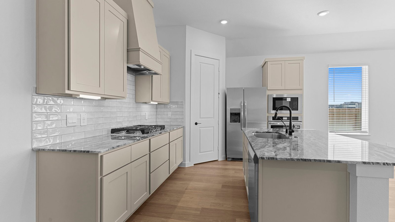 An open concept kitchen with an island with bar seating and access to the living and dining areas.