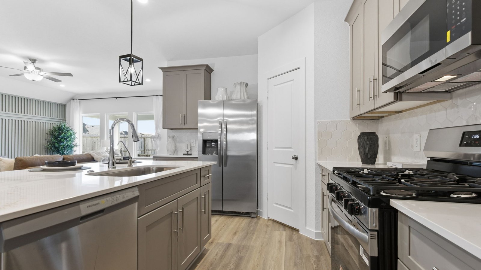 An open concept kitchen with an island with bar seating and access to the living and dining areas.
