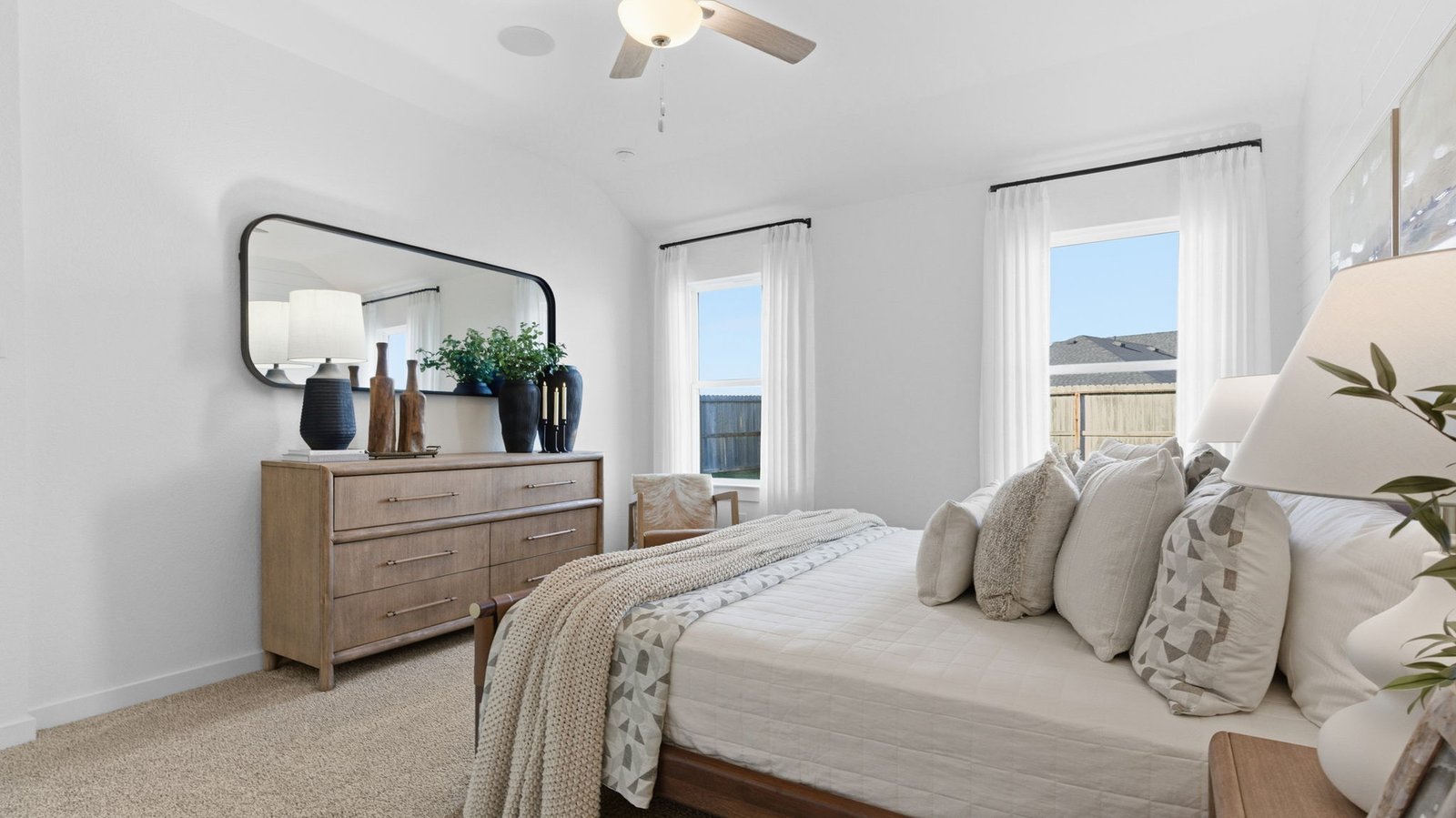 Primary bedroom with ceiling fan, plush carpeting, and a large walk-in closet.